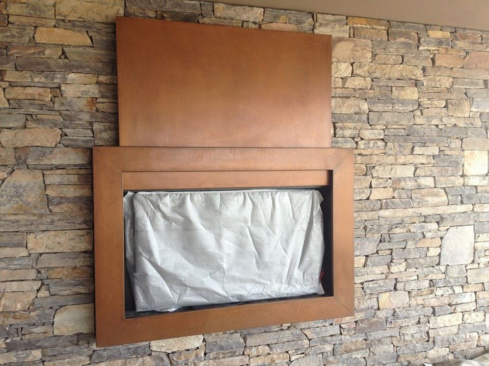 Copper fireplace surround on stone wall — WeldDone Arizona